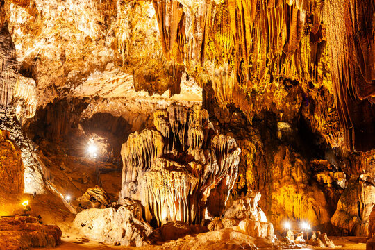 Illuminated limestone stalactites and stalagmites fill the cavern interior of Tham Loub Cave near Vang Vieng, Laos.
