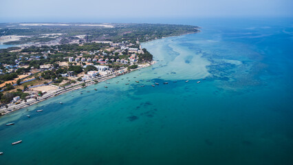 Fototapeta premium Aerial drone view of the Rameswaram coastline in Tamil Nadu, India, featuring turquoise coastal waters, sandy shoreline, fishing boats, and the vibrant island town.