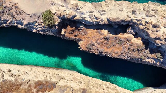Drone view of Papafragas beach on Milos island in Greece, flying above a cave with turquoise sea water in the Aegean Sea, Mediterranean beach vacation in Greece, holiday in the Cyclades