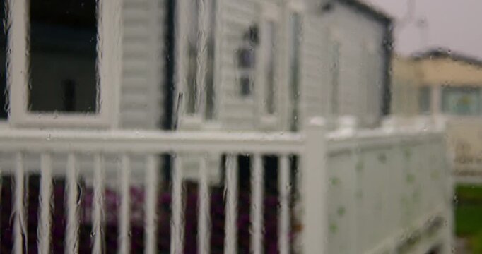 zoom Shot of rain on a static caravan window with static caravans in background at Fleetwood, blackpool