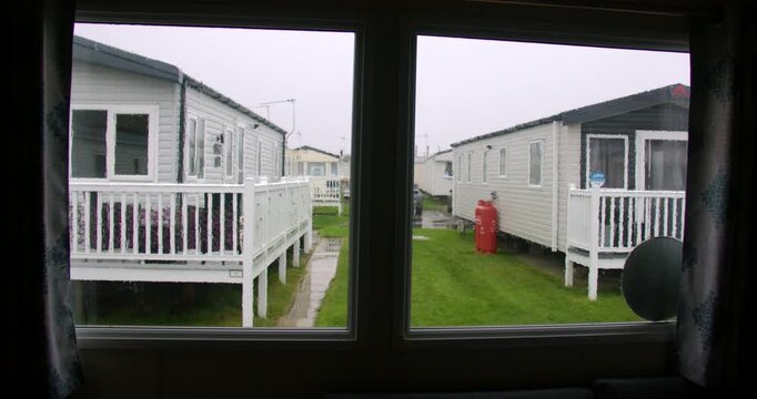 Wide zoom Shot of rain on a static caravan window with static caravans in background at Fleetwood, blackpool
