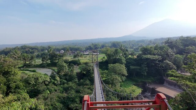 Beautiful morning aerial drone view of a bridge over a river on the slopes of majestic Mount Merapi volcano, Indonesia