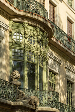Barcelona's Eixample district showcasing an ornate Modernisme building facade with a prominent green bay window and intricate wrought iron balconies, reflecting the city's architectural heritage