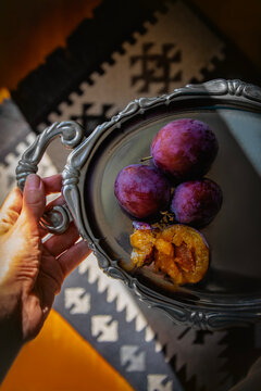 Fresh ripe plums, national fruit of Serbia, on a decorative silver tray 