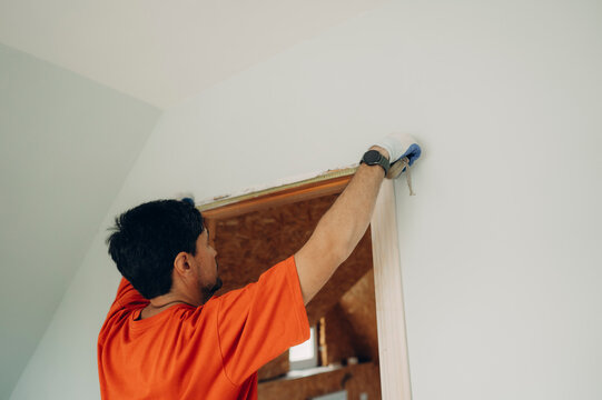 Man measures the door frame with a roulette during home renovation