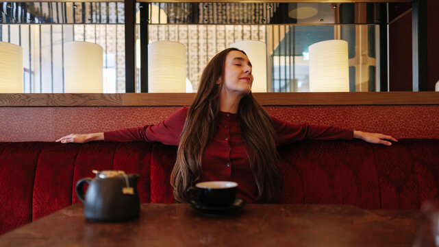 Woman relaxes with a cup of tea at a hotel cafe