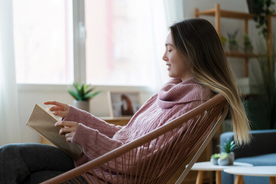 Callm woman reading a book at home in a cozy living room