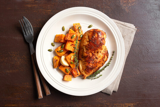Autumn meal: roasted chicken breast and pumpkin with herbs
