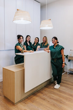 Female colleagues smile at the reception desk in a beauty clinic