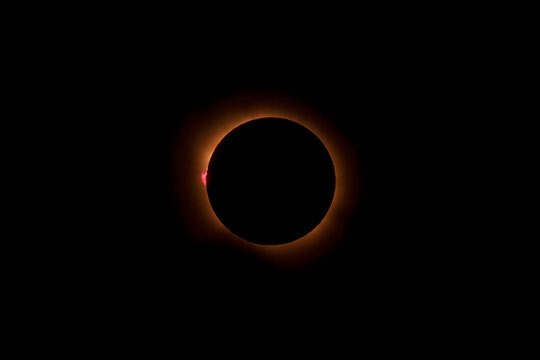 The moon covers the sun during a total solar eclipse in the dark sky