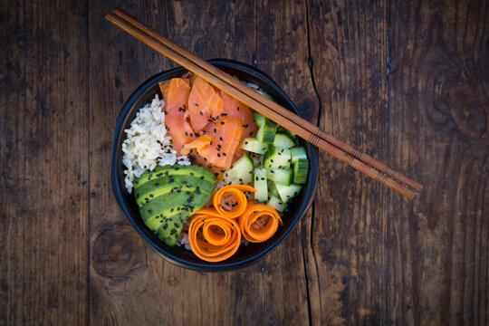 Sushi-Bowl with salmon, avocado, cucumber, rice and carrot