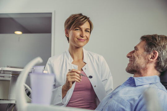 Female dentist talking to her patient before treatment