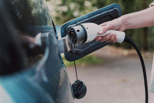 Woman charging her electric vehicle at home