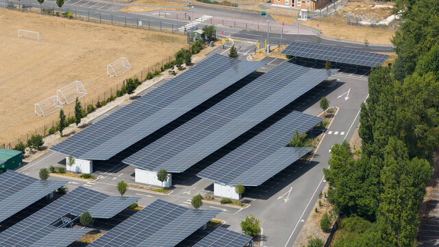 Aerial view shows a solar panel carport in an empty parking lot