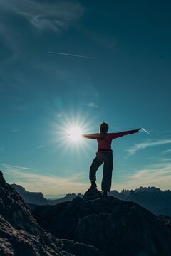 Woman celebrates success on a mountain summit in the Dolomites