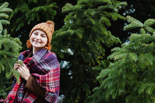 Smiling woman enjoys holiday shopping at outdoor Christmas market