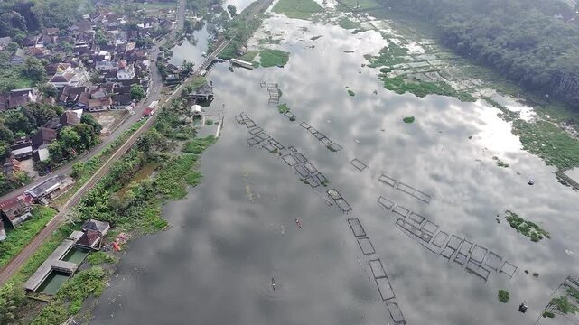 Beautiful aerial drone view of the Blue Bridge (Jembatan Biru Sumurup) at Rawa Pening lake with local village houses in Semarang, Central Java, Indonesia.