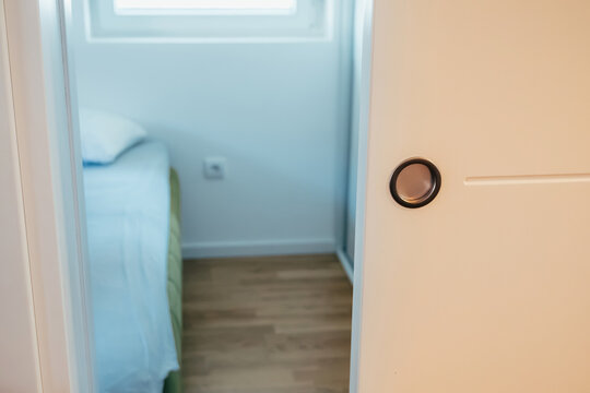 Real estate listing or rental concept: bedroom door with round knob, blurred interior beyond. Home and property