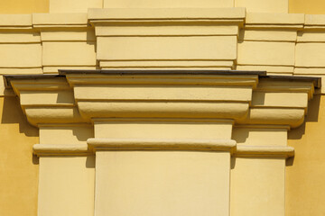 Classic architectural cornice against warm yellow wall © schankz
