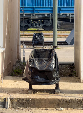 Black plastic bag covers a trash bin outdoors