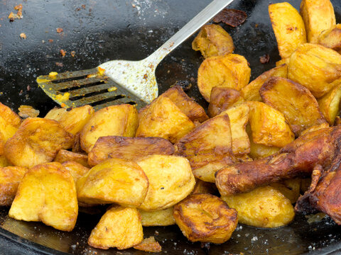 Golden fried potato cubes sizzle on a hot pan