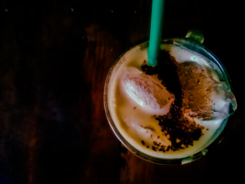 Close up of iced capuccino coffee with dark color background wood table.