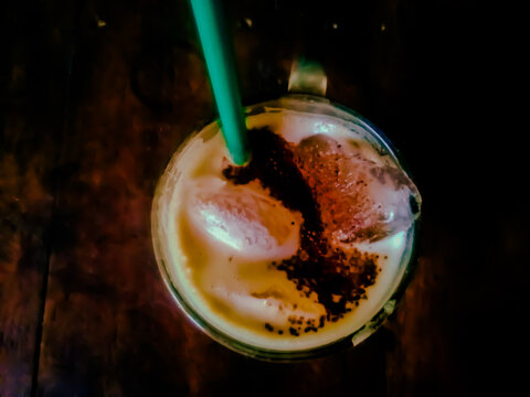 Close up of iced capuccino coffee with dark color background wood table.