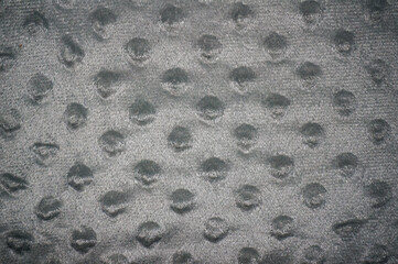 Grey dimple dot minky fabric texture background, soft embossed plush fleece textile close up © Rendi
