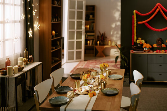 Festive dining table arranged for Indian Diwali festival celebration with flowers, candles, dishes. Visual content ideal for holiday marketing campaigns, cultural event promotions