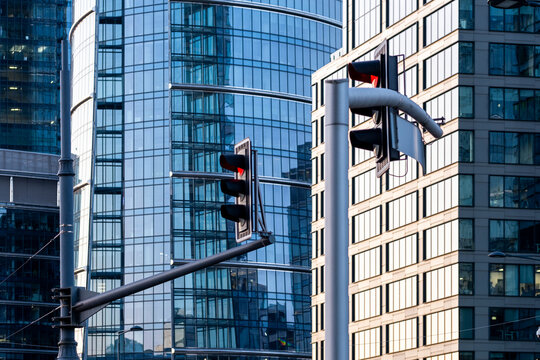 Traffic light in Warsaw stands against modern glass buildings as urban architecture frames the city street and the buildings rise around it