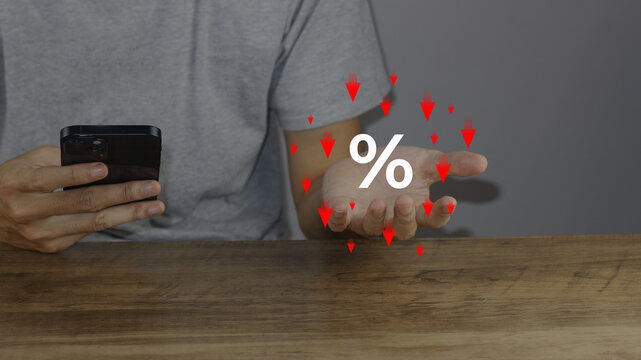 Show percentage icon with red downward arrows hovering on hand holding smartphone, special offer shopping discount tax concept, adjusting interest rates to fight inflation, finance returns