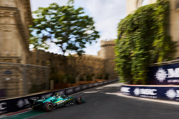 Obraz premium BAKU, AZERBAIJAN - SEPTEMBER 2026: Aston Martin F1 car navigates the narrow castle section past the medieval fortress walls during the Formula 1 Azerbaijan Grand Prix 2026