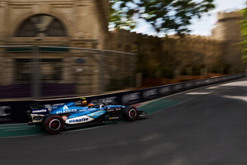 Obraz premium BAKU, AZERBAIJAN - SEPTEMBER 2026: Williams Racing F1 car turns through the narrow Castle section past medieval fortress walls during Formula 1 Azerbaijan Grand Prix 2026