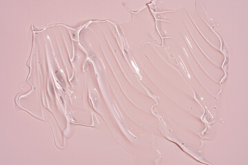 Fototapeta premium Transparent cosmetic gel texture smudge with air bubbles on pink background