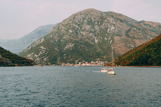 Sailing through a narrow bay with mountains in the background during the afternoon