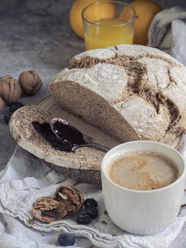 Artisan walnut bread with blackberry jam and coffee with milk.