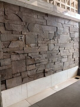 Modern Ablution Area with Stone Wall and Stainless Steel Faucets for Wudhu