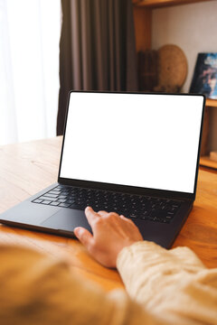 Vertical mockup image of a woman working on laptop computer with blank screen at home