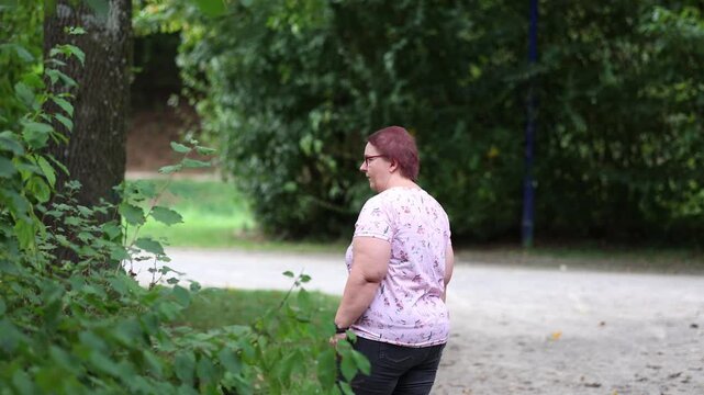 Woman urinating in public park bushes
