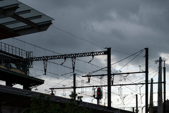 Railway platforms and overhead power lines in Lyon France form an urban transport infrastructure city scene beneath a dark cloudy sky