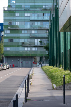 Modern building facade beside an urban walkway in Lyon France combines glass architecture and greenery in a clean contemporary city view