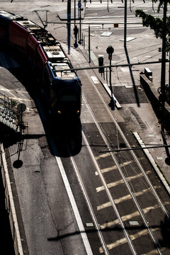 Tram moves along urban tracks in Lyon France beneath overhead wires as transport infrastructure and city mobility shape a high angle street view