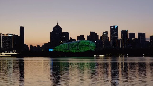 Shenyang, China city skyline reflected on river at dusk