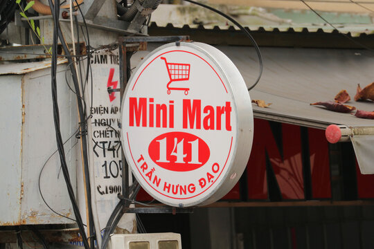 Round outdoor illuminated lightbox signboard of Mini Mart 141 store on Tran Hung Dao street in Hoi An, Vietnam on January 25, 2026.