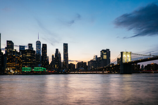 Brooklyn Bridge and Manhattan skyline at dusk over the East River in New York City, USA