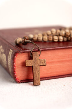 Wooden Cross and Rosary on Closed Bible