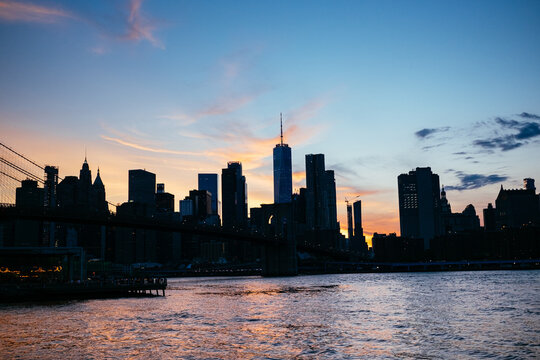 Brooklyn Bridge and Manhattan skyline at dusk over the East River in New York City, USA