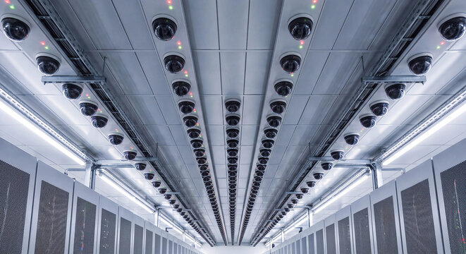 Rows of security dome cameras on server room ceiling mass surveillance concept photo