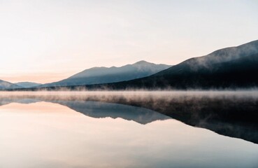 Fototapeta premium 薄霧が漂う湖と山並みの静かな水鏡風景