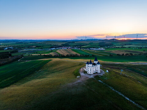 Isolated Castle with Wind Turbines at Sunset